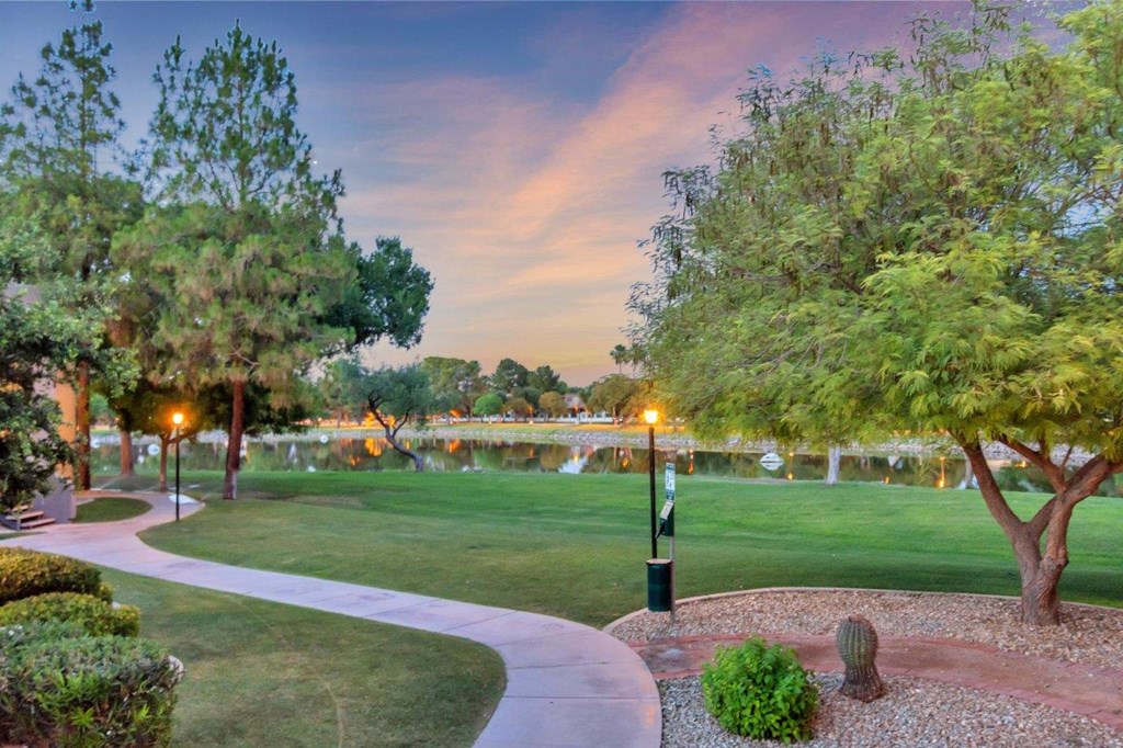 a walkway through a park next to a body of water