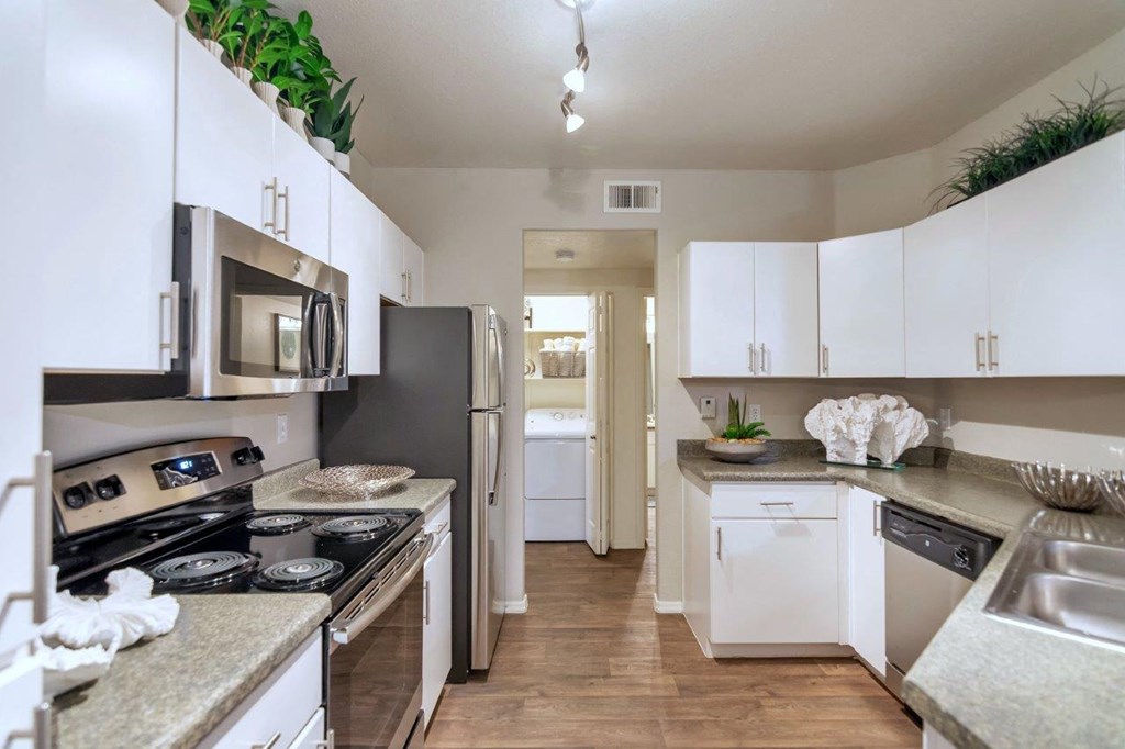 a kitchen with white cabinets and stainless steel appliances