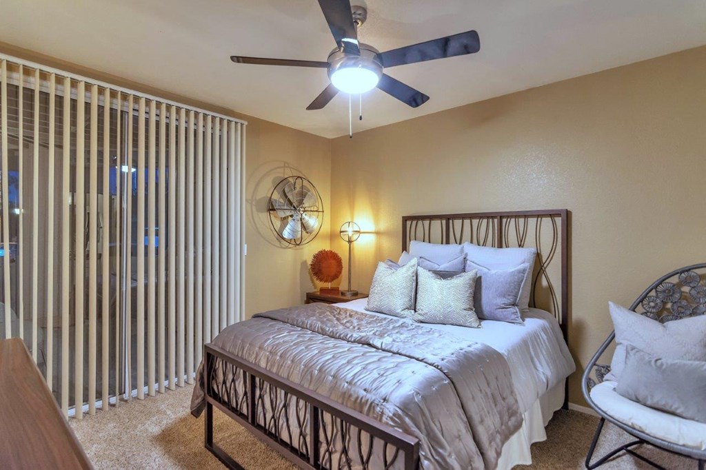 a bedroom with a bed and a ceiling fan