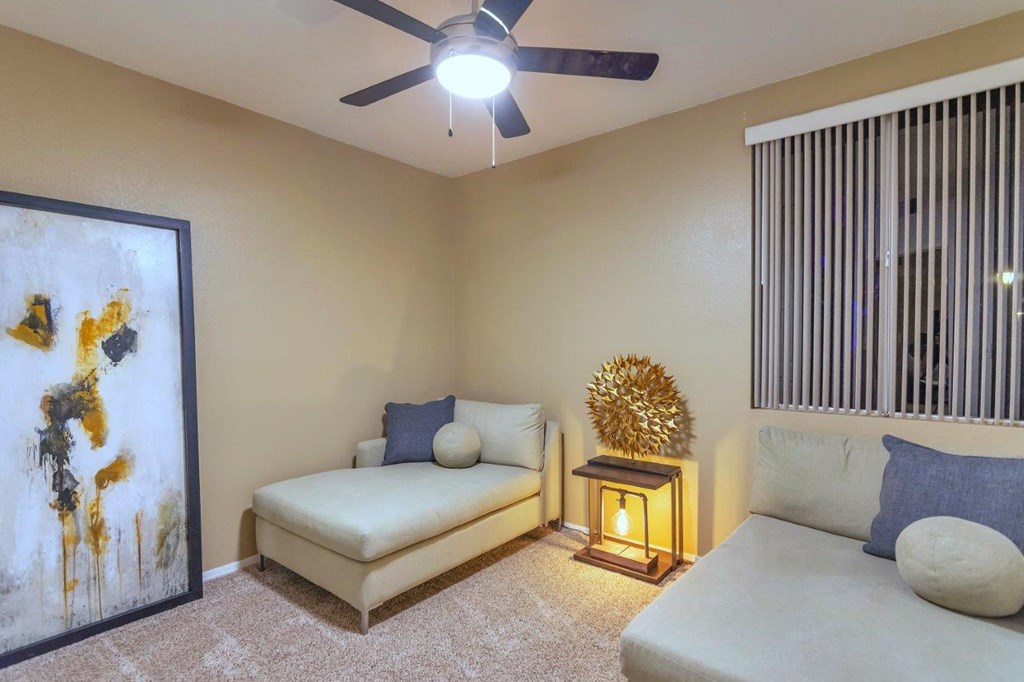 a living room with a couch and a ceiling fan
