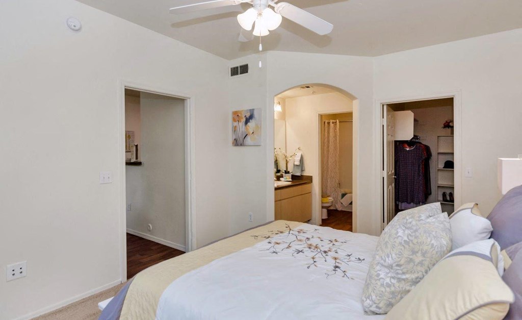 a bedroom with a large bed and a ceiling fan