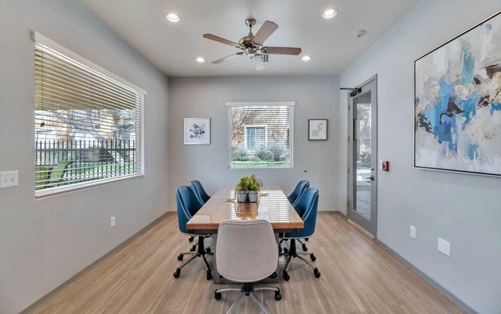 a conference room with a table and chairs and a ceiling fan