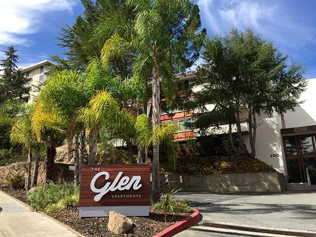 a sign in front of a building with palm trees