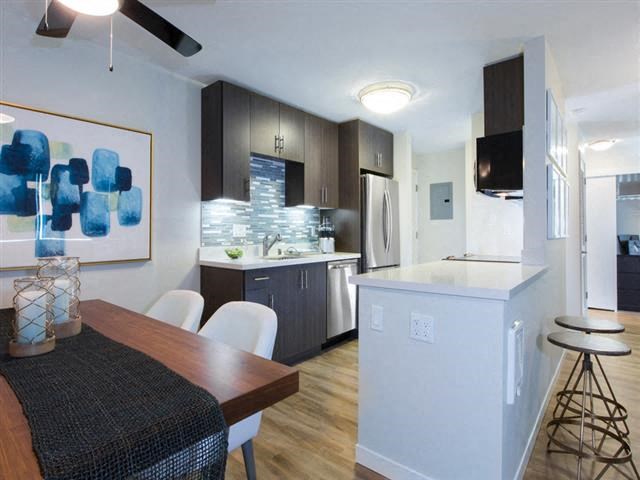 a kitchen and a dining room with a table and chairs