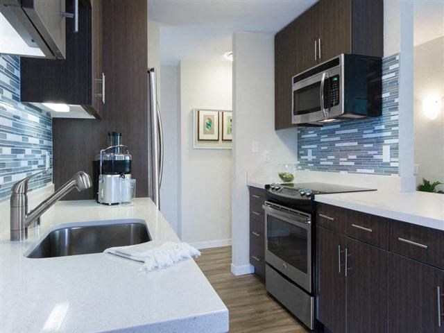 a kitchen with a sink a stove and a microwave