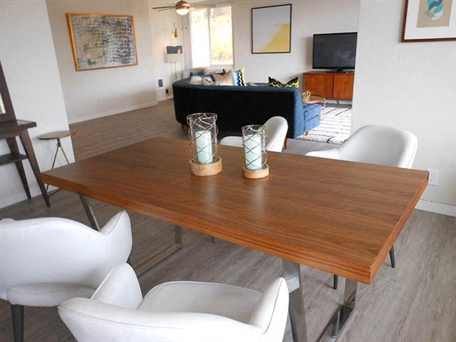 a dining table with white chairs in a living room