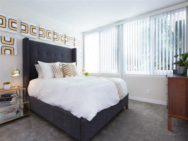 a bedroom with a large bed and some windows
