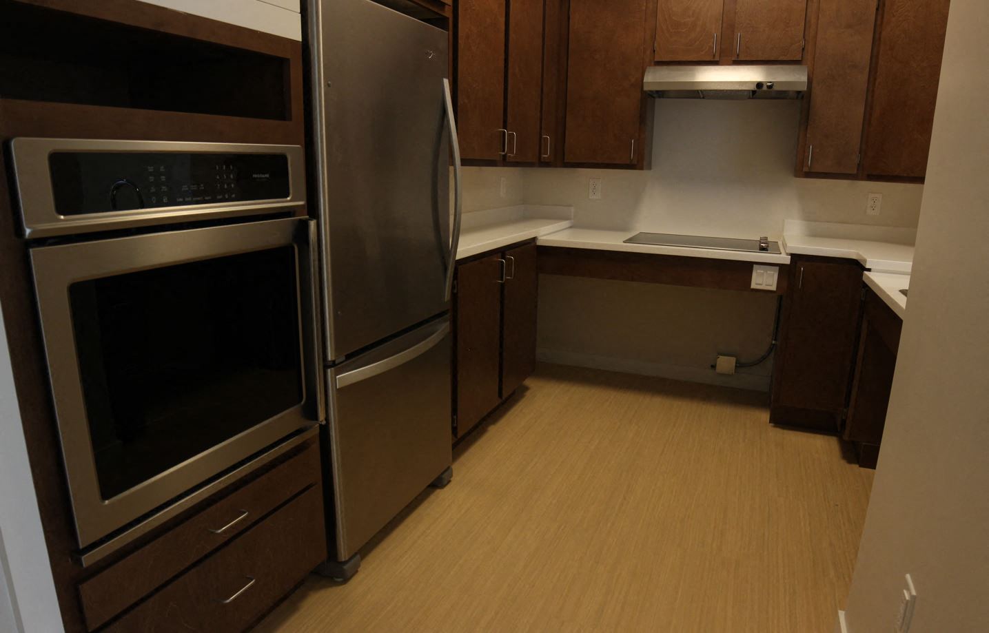 a kitchen with stainless steel appliances and wooden floors