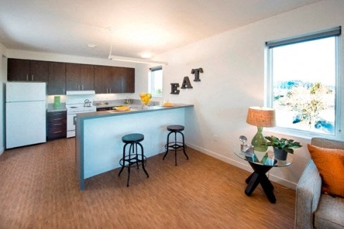 a kitchen and living room with a blue bar and stools