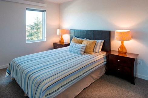 a bedroom with a bed and two night stands and a window