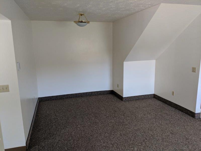 an empty room with a carpeted floor and white walls