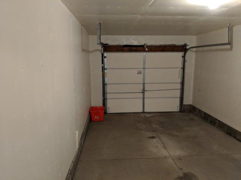 a garage with a white wall and a garage door