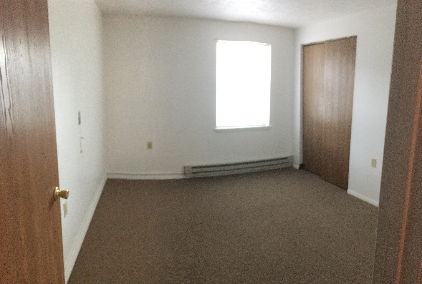 an empty room with a door and a window