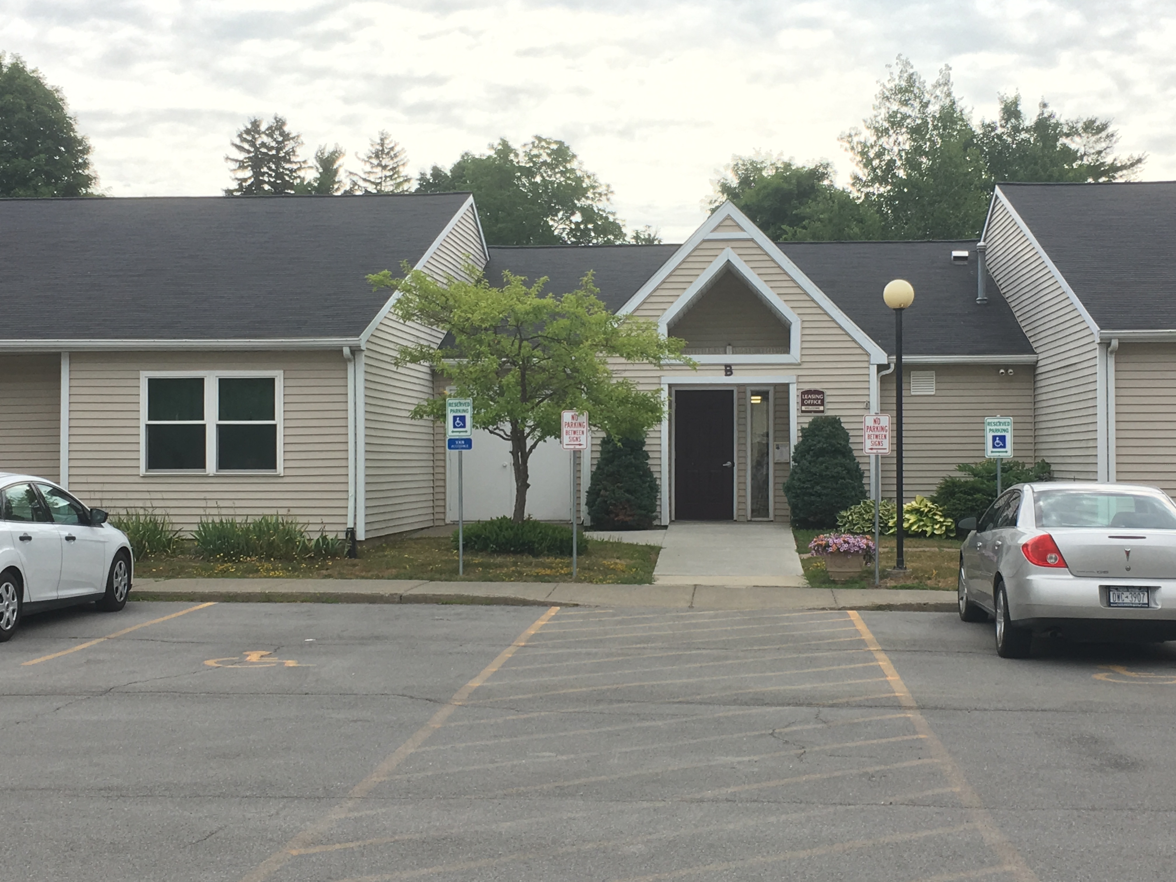 a house with a parking lot and cars in front of it