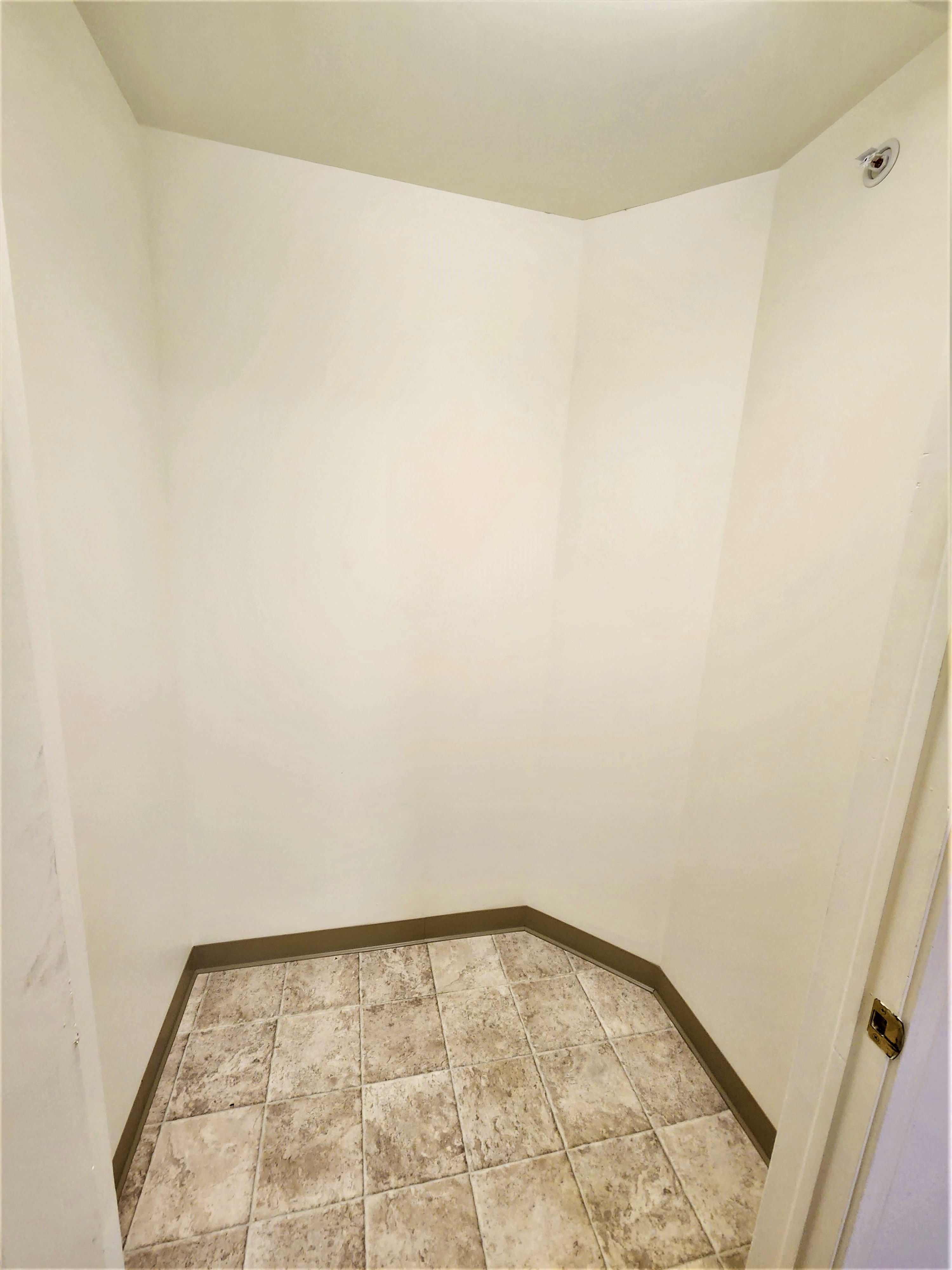an empty bathroom with a tiled floor and white walls