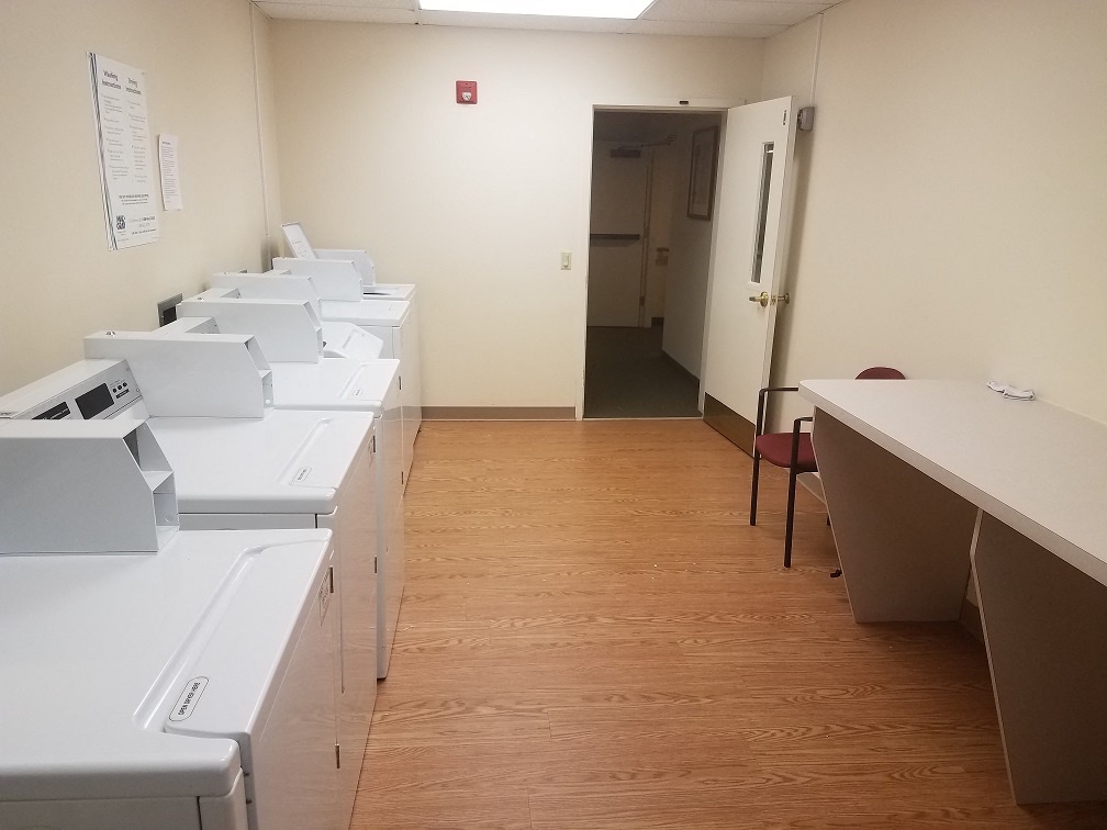 a room filled with printers and desks and a door to a hallway