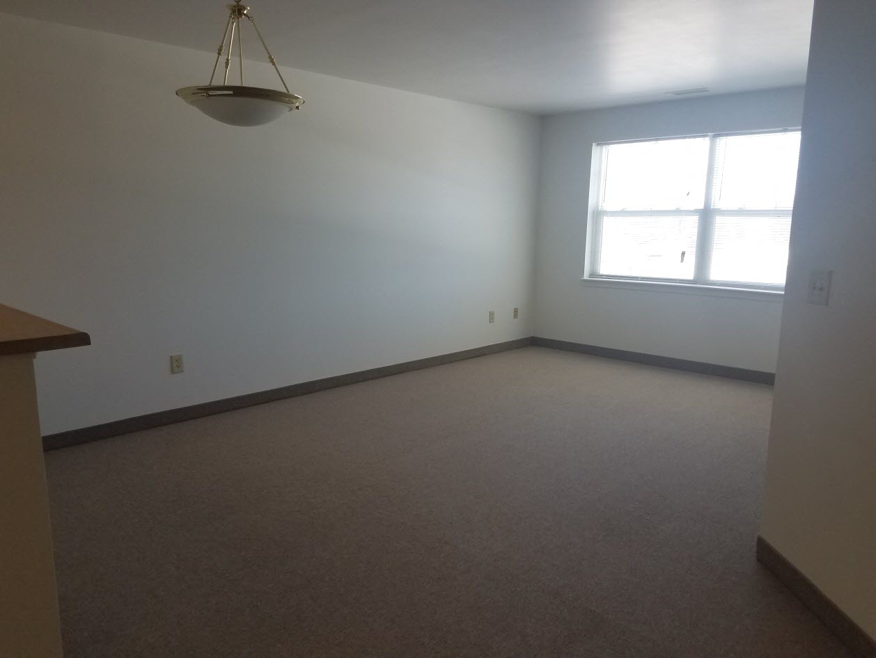 an empty room with a window and a lamp