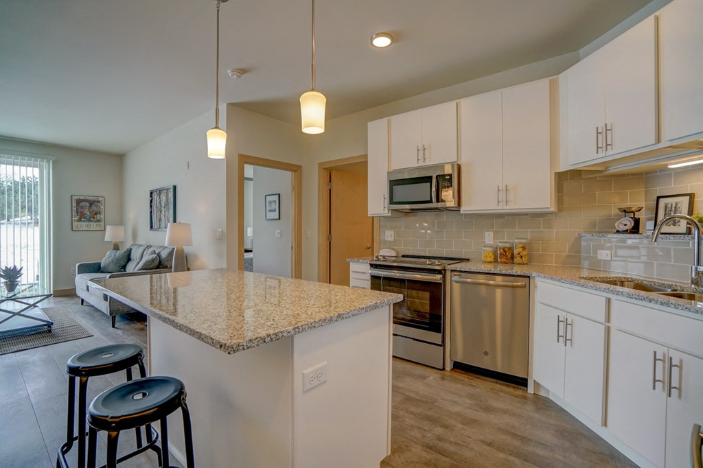 a kitchen with white cabinets and a granite counter top