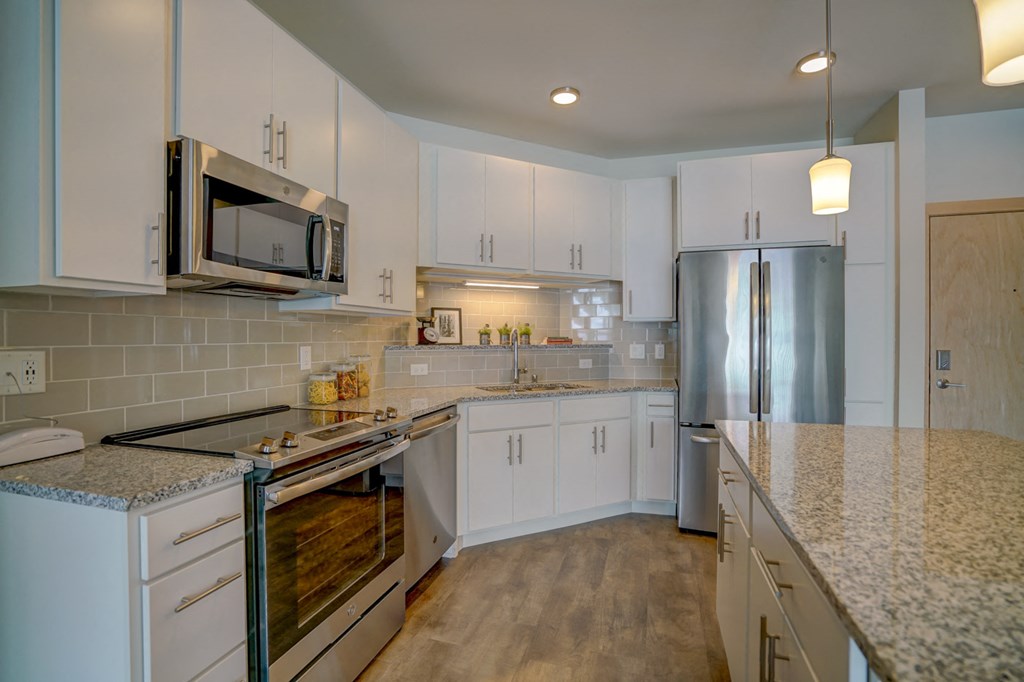 a kitchen with white cabinets and a counter top
