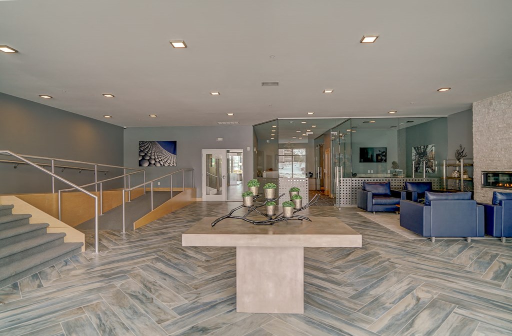 a lobby with blue chairs and a marble table