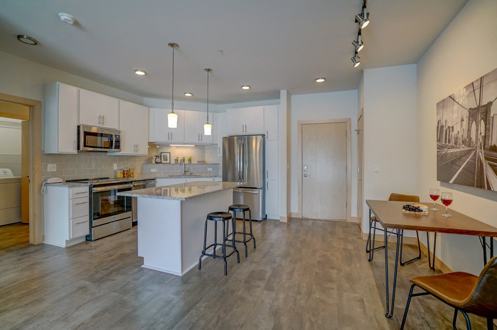 a kitchen with an island and a dining table with stools