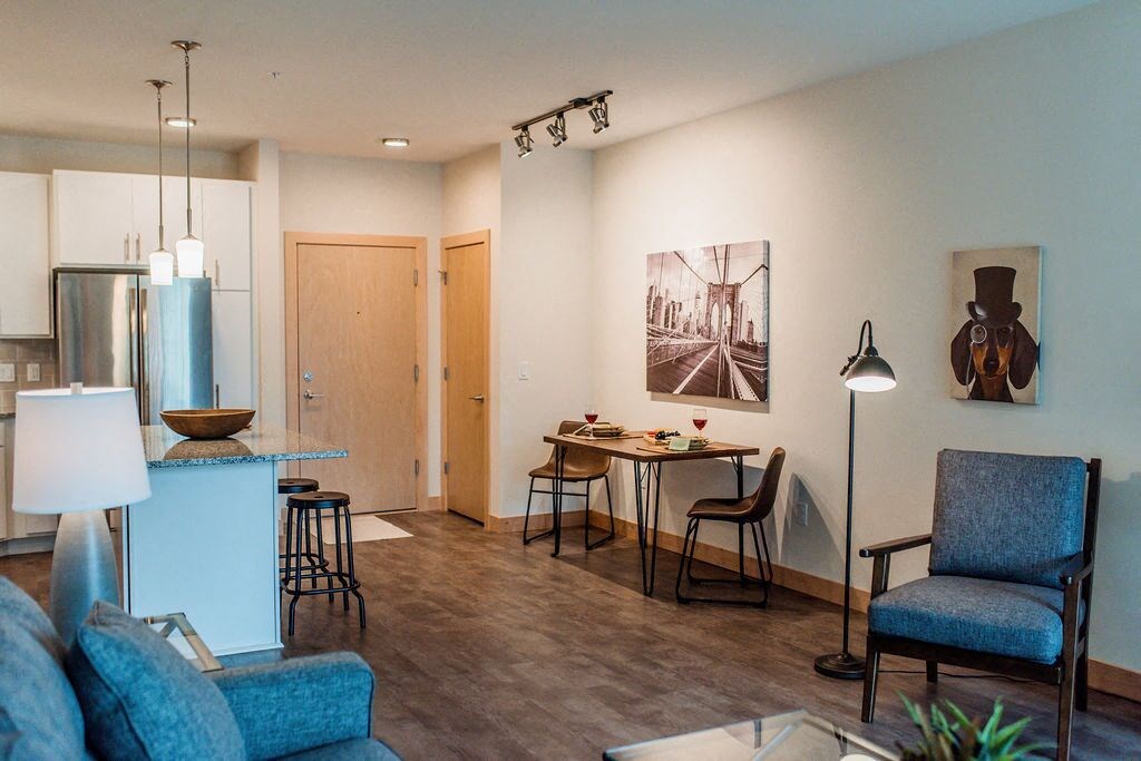 a living room and kitchen with a table and chairs