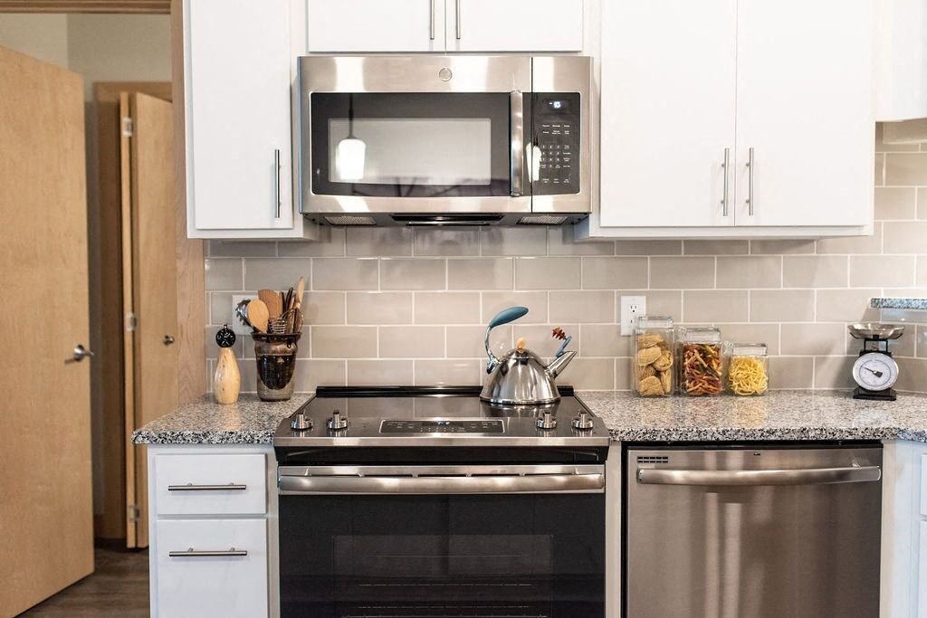 a kitchen with stainless steel appliances and white cabinets