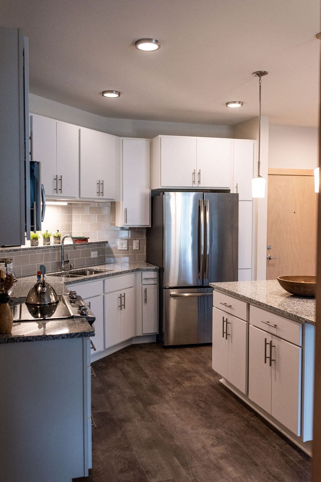 a kitchen with white cabinets and stainless steel appliances