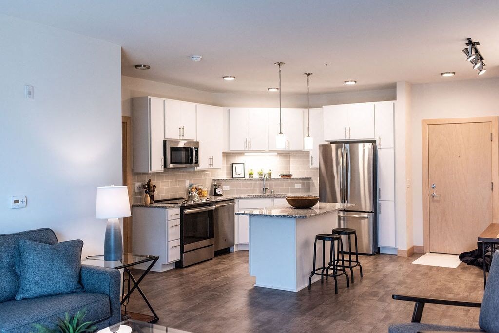 a kitchen with an island in the middle of a living room