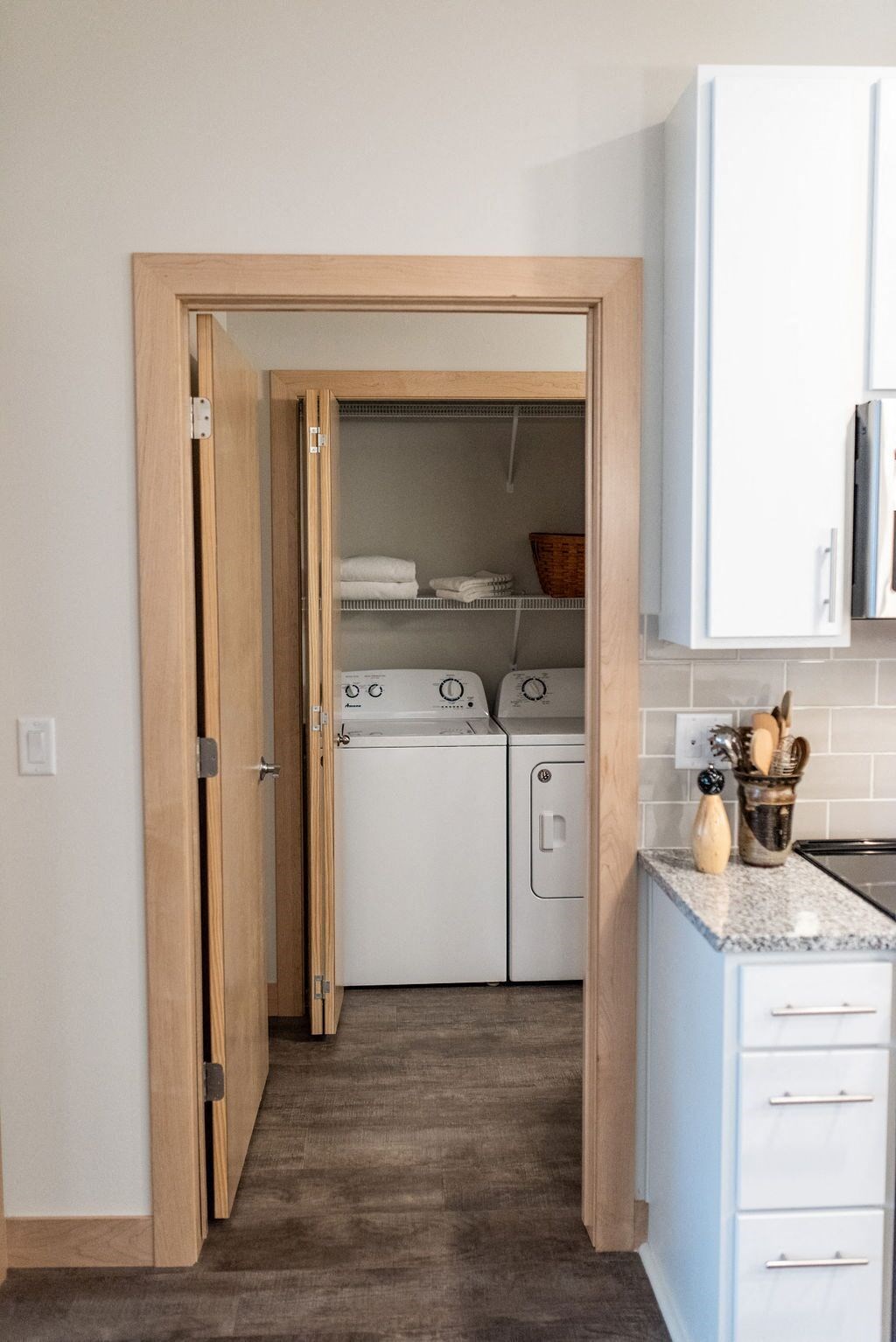 a white washer and dryer in a kitchen with a wooden door