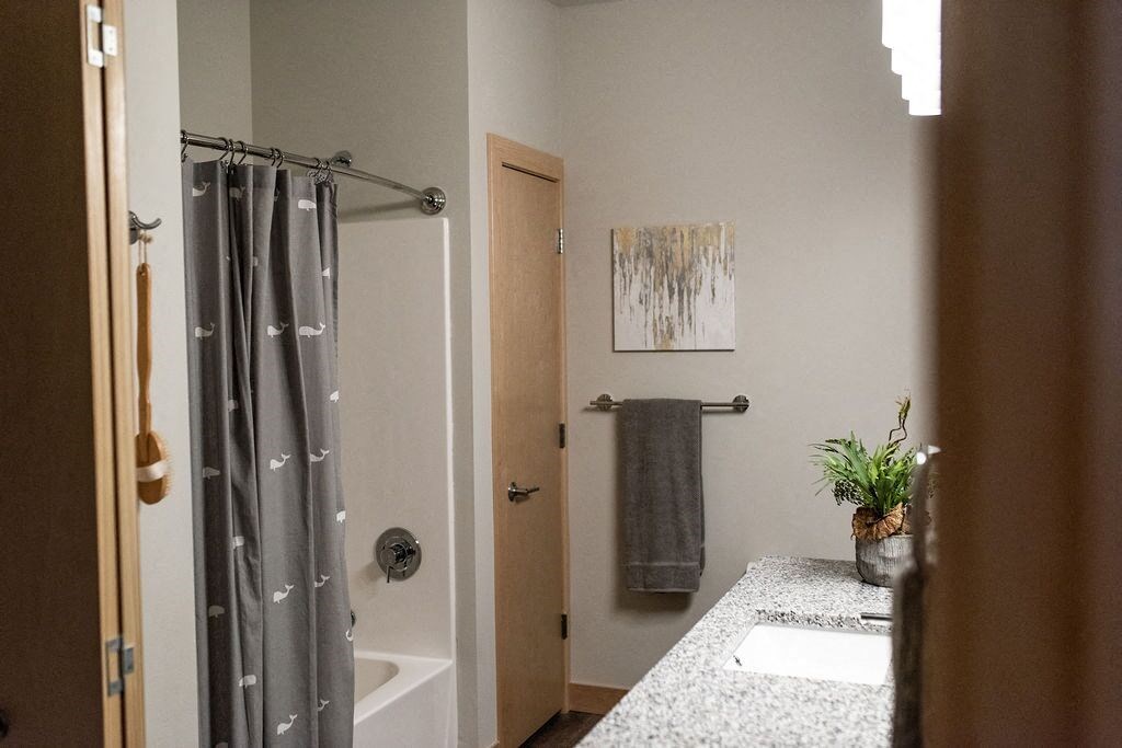 a bathroom with a shower and a sink and a towel