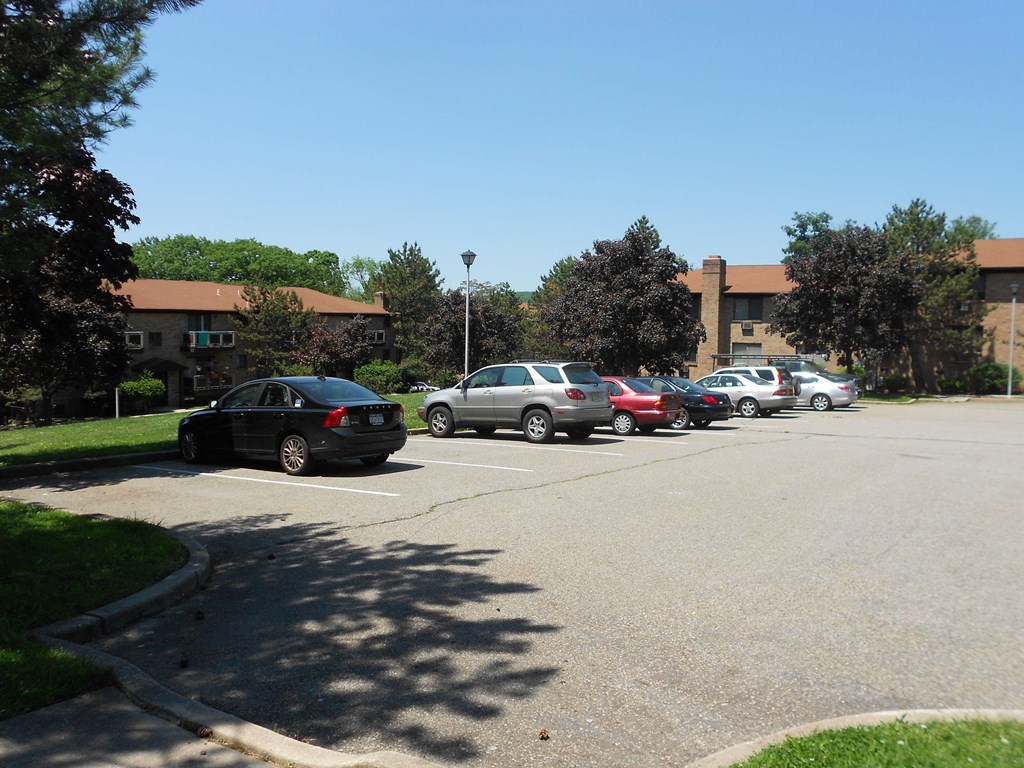 A parking lot with cars and a building in the background.