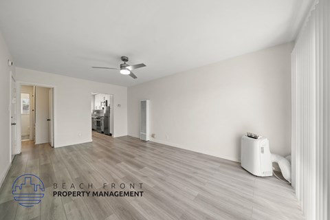 A spacious room with a fan and a portable air conditioner.