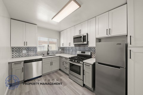 A kitchen with stainless steel appliances and white cabinets.