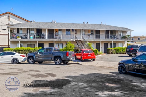 a parking lot with cars in front of an apartment building