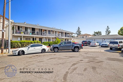 a parking lot with cars in front of an apartment building