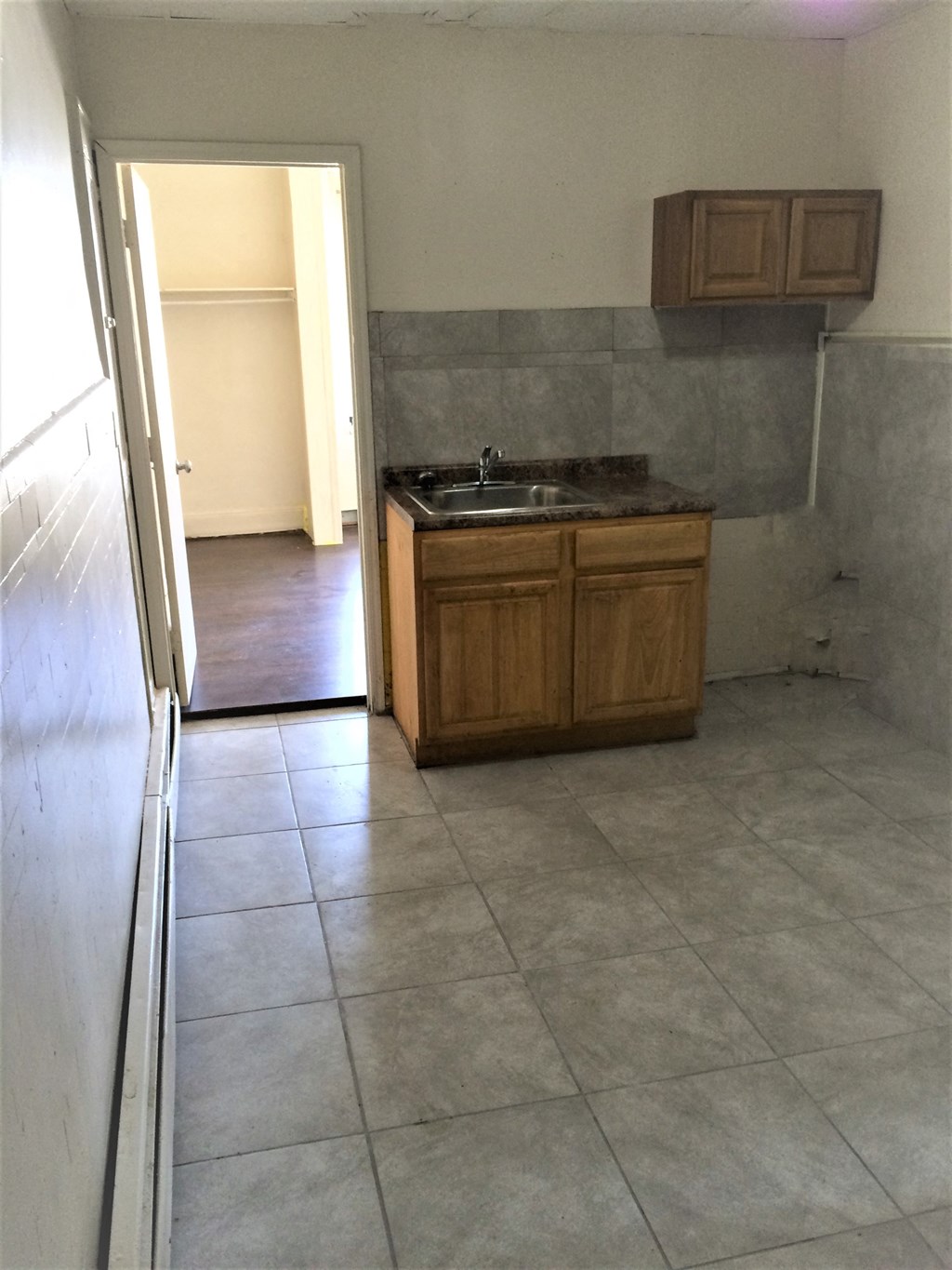 an empty kitchen in a house with a sink and cabinets