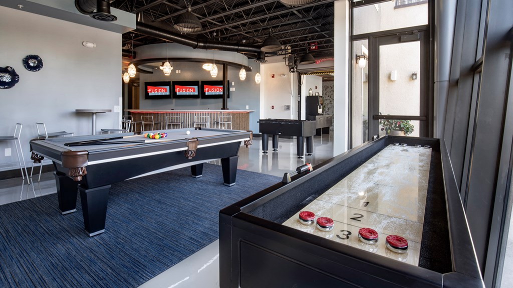 A room with a pool table and air hockey table.