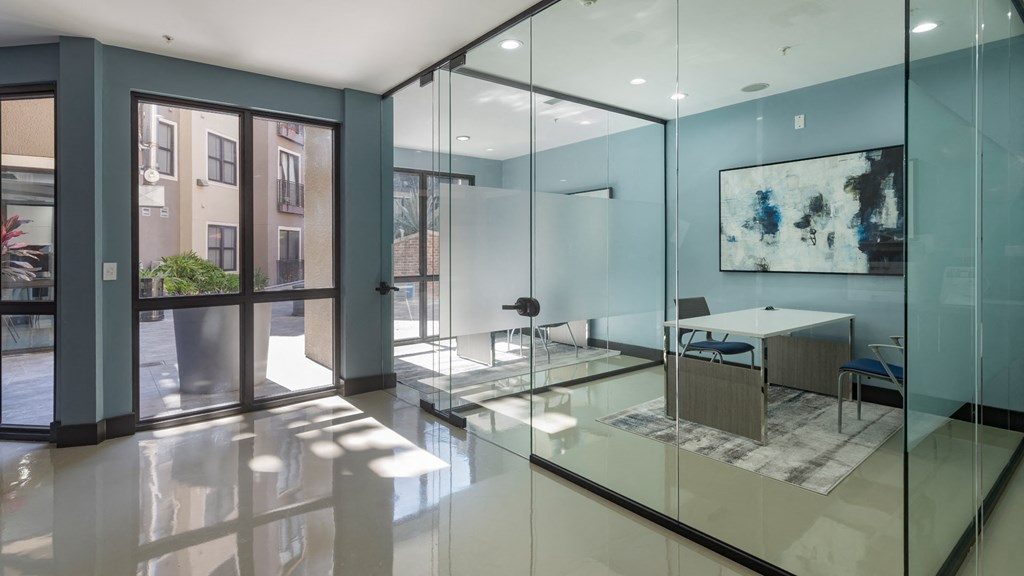 A modern office with glass walls and a view of the street outside.