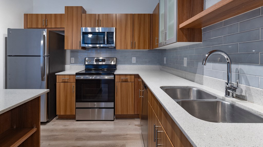 A modern kitchen with wooden cabinets and stainless steel appliances.