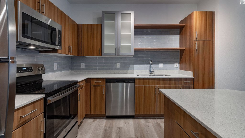 A modern kitchen with wooden cabinets and stainless steel appliances.