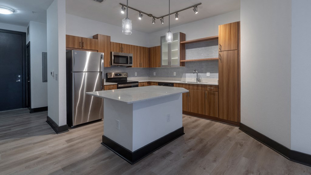 A modern kitchen with a white island and stainless steel appliances.