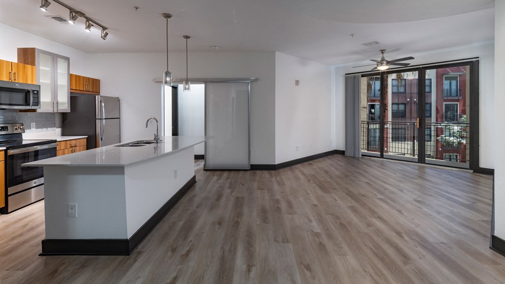 A kitchen with a refrigerator, sink, and stove.