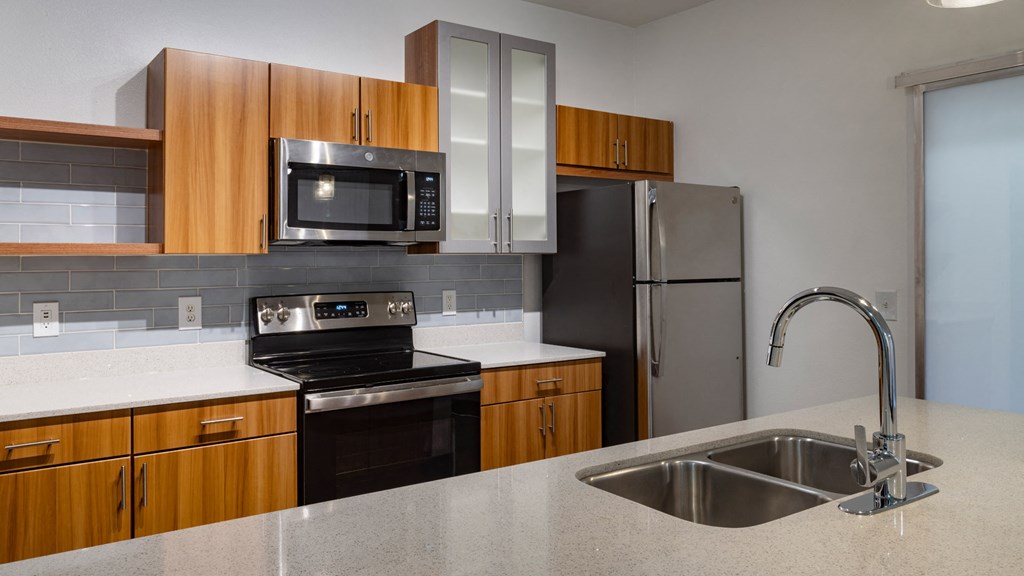 A kitchen with a black stove, a black microwave, and a black refrigerator.