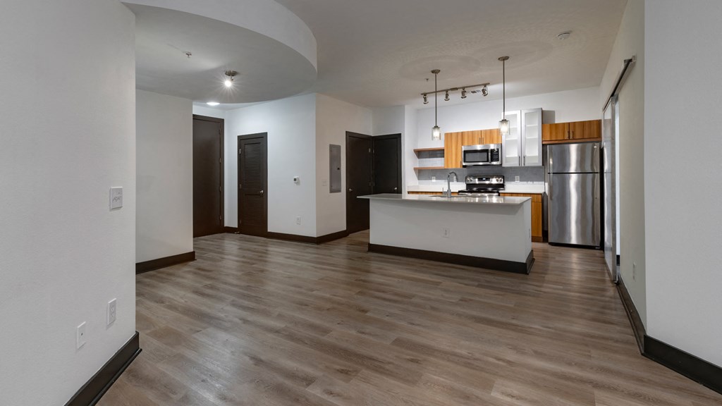 A kitchen with a refrigerator, microwave, and oven is shown.