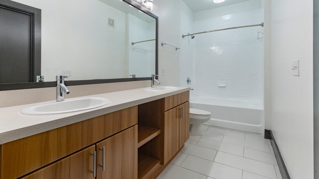 A bathroom with a sink, mirror, and toilet.
