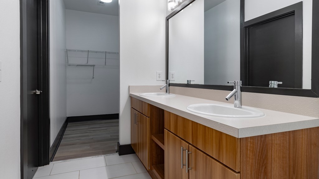 A bathroom with a sink, mirror, and wooden cabinets.