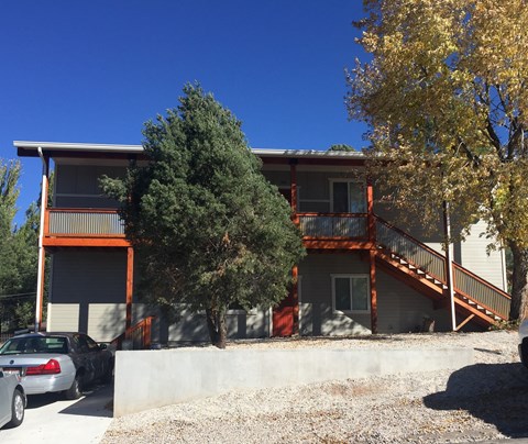 an exterior view of a building with cars parked in front of it