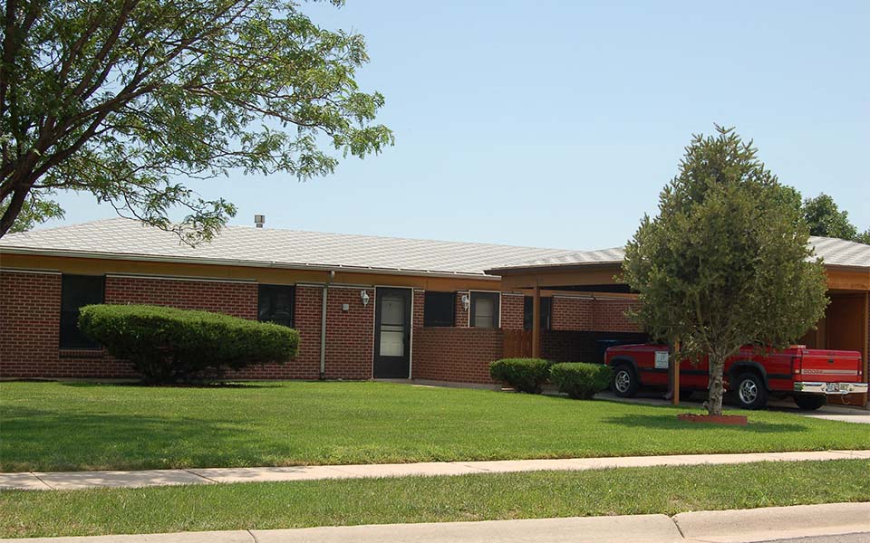 a red truck parked in front of a brick house