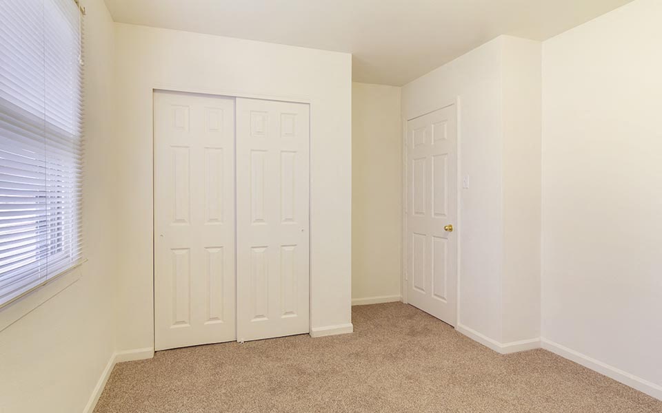 a bedroom with two closets and two doors